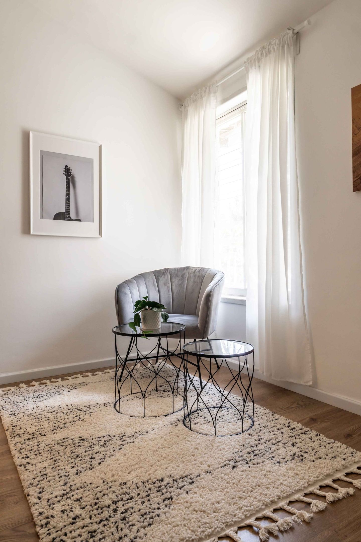 פינת ישיבה מתחת לחלון בגוון אפור ושמנת